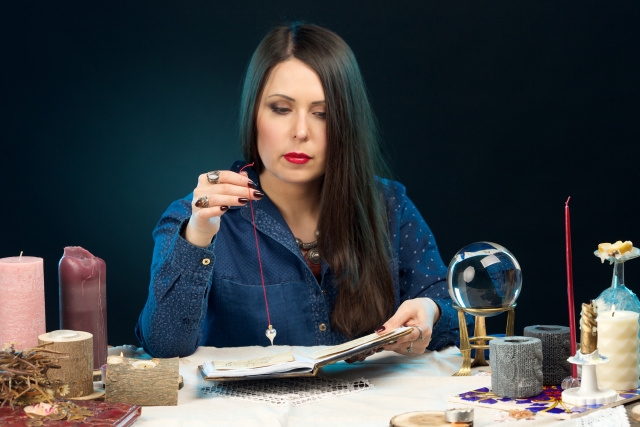 ペンデュラムで占いをする女性